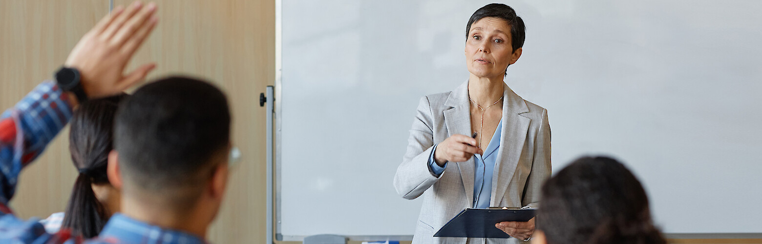 Zwei Frauen arbeiten am Laptop und unterhalten sich mit einem Lächeln im Gesicht