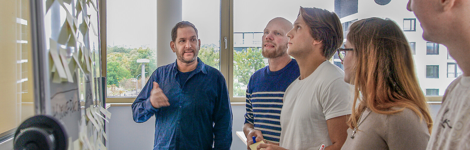 Creative Direction Master berufsbegleitend Dresden: Studierende besprechen Designkonzept im lichtdurchfluteten Studio