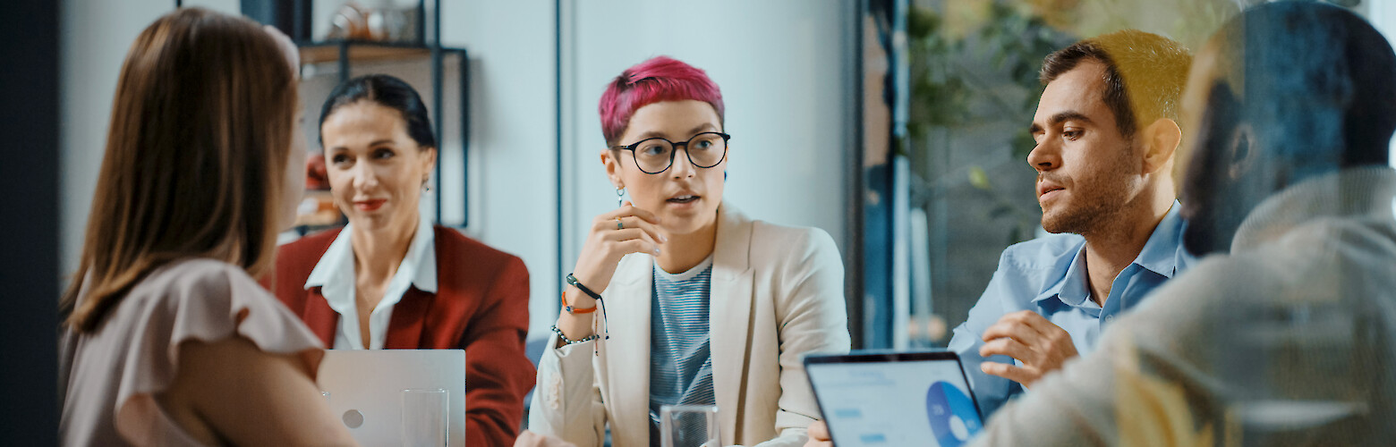 Eine Gruppe aus fünf Personen bei einem Business Meeting. Das Studium in der Fakultät Betriebswirtschaft an der FHD legt den Grundstein für eine Karriere im Management.